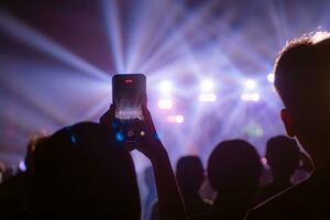 mensen Holding slim telefoon en opname en fotograferen in concert , silhouet van handen met mobiel , evenement achtergrond concept foto