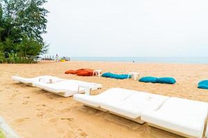 lege strandstoel op zand met oceaanzeeachtergrond