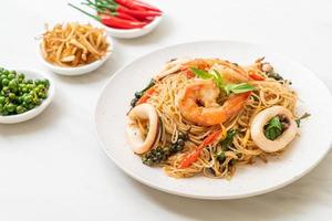 Geroerbakte Chinese noedels met basilicum, chili, garnalen en inktvis - Aziatisch eten foto