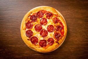 pepperoni pizza op houten dienblad - Italiaanse eetstijl food foto