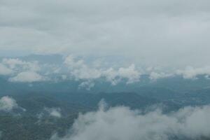 mooi panoramisch visie van mist en wolken in ver weg lagen bergen reeks met blauw lucht in ochtend- foto