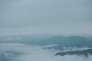 berg reeks met zichtbaar silhouetten door de ochtend- blauw mist. foto