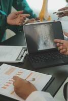 groep van artsen lezing een document in vergadering kamer Bij ziekenhuis foto