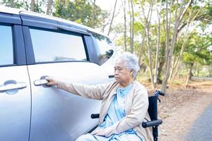 Aziatische senior of oudere oude dame vrouw patiënt zittend op rolstoel voorbereiden om naar haar auto te gaan, gezond sterk medisch concept. foto