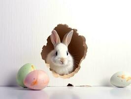konijn gluurt uit gat in de wit muur met kleurrijk Pasen ei.generatief ai. foto