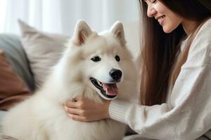 vrouw in een wit trui strelen een hond Aan de bed foto