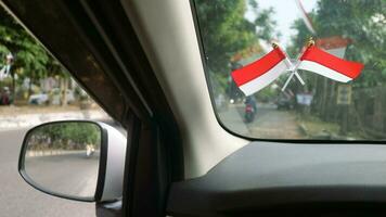 de Indonesisch vlag is gemonteerd Aan de voorruit van de auto naar Welkom Indonesië's onafhankelijkheid dag foto