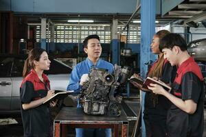 specialist lezing, een mannetje leidinggevende ingenieur trein en beschrijven automotive motoren met monteur arbeider personeel teams voor reparatie werk Bij auto onderhoud garage en onderhoud jobs in auto- industrie. foto