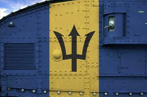 Barbados vlag afgebeeld Aan kant een deel van leger gepantserd tank detailopname. leger krachten conceptuele achtergrond foto