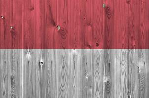 Monaco vlag afgebeeld in helder verf kleuren Aan oud houten muur. getextureerde banier Aan ruw achtergrond foto