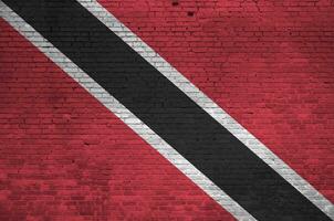 Trinidad en Tobago vlag afgebeeld in verf kleuren Aan oud steen muur. getextureerde banier Aan groot steen muur metselwerk achtergrond foto