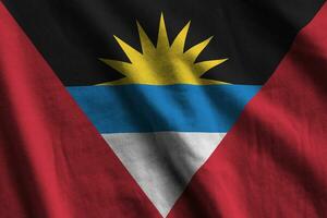 antigua en Barbuda vlag met groot vouwen golvend dichtbij omhoog onder de studio licht binnenshuis. de officieel symbolen en kleuren in banier foto