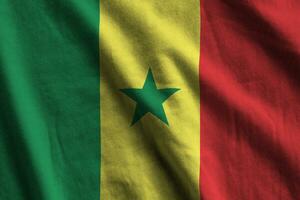 Senegal vlag met groot vouwen golvend dichtbij omhoog onder de studio licht binnenshuis. de officieel symbolen en kleuren in banier foto