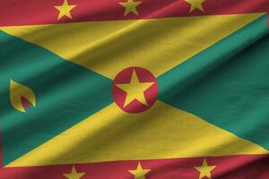 Grenada vlag met groot vouwen golvend dichtbij omhoog onder de studio licht binnenshuis. de officieel symbolen en kleuren in banier foto