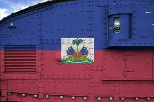 Haïti vlag afgebeeld Aan kant een deel van leger gepantserd tank detailopname. leger krachten conceptuele achtergrond foto