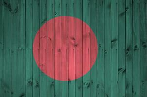 Bangladesh vlag afgebeeld in helder verf kleuren Aan oud houten muur. getextureerde banier Aan ruw achtergrond foto