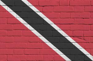 Trinidad en Tobago vlag afgebeeld in verf kleuren Aan oud steen muur. getextureerde banier Aan groot steen muur metselwerk achtergrond foto