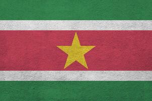 Suriname vlag afgebeeld in helder verf kleuren Aan oud Verlichting bepleistering muur. getextureerde banier Aan ruw achtergrond foto