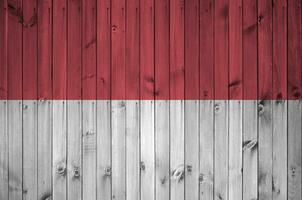 Indonesië vlag afgebeeld in helder verf kleuren Aan oud houten muur. getextureerde banier Aan ruw achtergrond foto