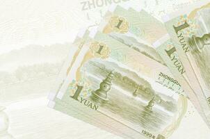 1 Chinese yuan rekeningen leugens in stack Aan achtergrond van groot semi-transparant bankbiljet. abstract presentatie van nationaal valuta foto