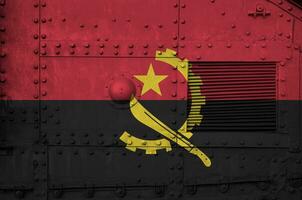 Angola vlag afgebeeld Aan kant een deel van leger gepantserd tank detailopname. leger krachten conceptuele achtergrond foto