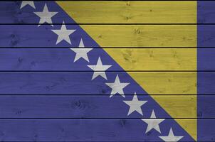 Bosnië en herzegovina vlag afgebeeld in helder verf kleuren Aan oud houten muur. getextureerde banier Aan ruw achtergrond foto