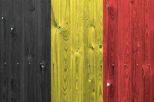 belgie vlag afgebeeld in helder verf kleuren Aan oud houten muur. getextureerde banier Aan ruw achtergrond foto