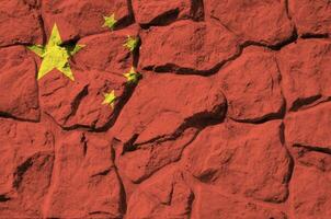 China vlag afgebeeld in verf kleuren Aan oud steen muur detailopname. getextureerde banier Aan rots muur achtergrond foto