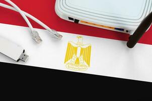 Egypte vlag afgebeeld Aan tafel met internet rj45 kabel, draadloze USB Wifi adapter en router. internet verbinding concept foto
