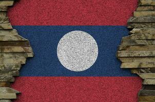 Laos vlag afgebeeld in verf kleuren Aan oud steen muur detailopname. getextureerde banier Aan rots muur achtergrond foto