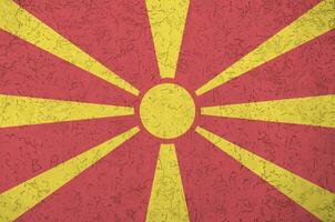 Macedonië vlag afgebeeld in helder verf kleuren Aan oud Verlichting bepleistering muur. getextureerde banier Aan ruw achtergrond foto