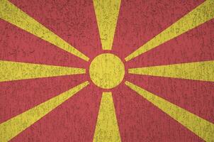 Macedonië vlag afgebeeld in helder verf kleuren Aan oud Verlichting bepleistering muur. getextureerde banier Aan ruw achtergrond foto