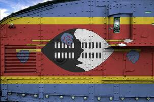 Swaziland vlag afgebeeld Aan kant een deel van leger gepantserd tank detailopname. leger krachten conceptuele achtergrond foto