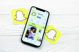 Charkov, Oekraïne - maart 5, 2021 snapchat icoon en toepassing van app op te slaan Aan iphone 12 pro Scherm scherm Aan wit tafel foto