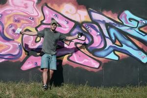 jong Kaukasisch mannetje graffiti artiest tekening groot straat kunst schilderij in blauw en roze tonen foto