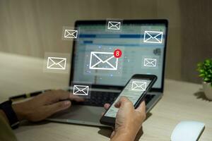 zakenman gebruik makend van laptop en mobiel smartphone met e-mail kennisgeving alarm Aan virtueel scherm. foto