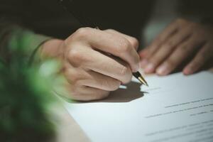 zakenman Holding een pen ondertekening een document, wet ,functie zoeken, schrijven een persoonlijk contract Aan bureau. foto