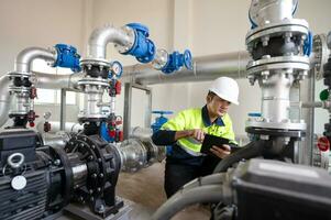 onderhoud ingenieurs inspecteren de systeem van pompen stations en pijpen leveren schoon water en water opslagruimte tanks voor de gemeenschap. foto