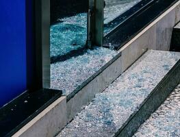gebroken glas in voorkant van een bedrijf Aan de straat na diefstal of vandalisme foto