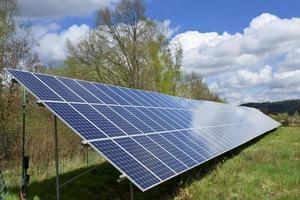 zonnecentrale op de voorjaarsbloeiende weide foto