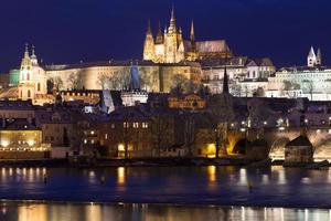 nacht kleurrijke besneeuwde kerst praag mindere stad met gotisch kasteel en charles bridge, tsjechische republiek foto