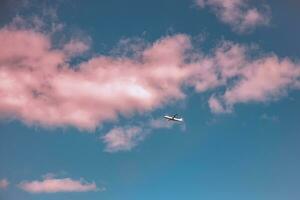vliegtuig in de lucht met roze wolken Bij zonsondergang. reis, vrijheid foto