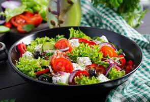gezond voedsel. Grieks salade met komkommer, tomaat, zoet peper, sla, rood ui, feta kaas en olijven. foto