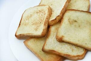 gebakken geroosterd brood Aan een wit bord. gebakken brood voor boterhammen. veganistisch voedsel. foto