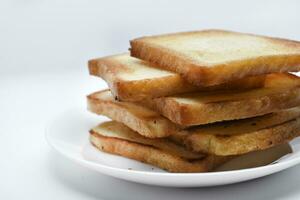 gebakken geroosterd brood Aan een wit bord. gebakken brood voor boterhammen. veganistisch voedsel. foto