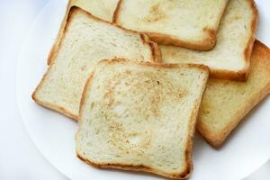 gebakken geroosterd brood Aan een wit bord. gebakken brood voor boterhammen. veganistisch voedsel. foto