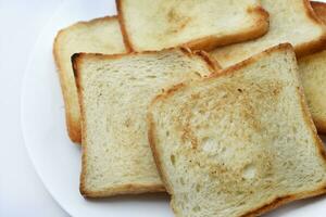 gebakken geroosterd brood Aan een wit bord. gebakken brood voor boterhammen. veganistisch voedsel. foto