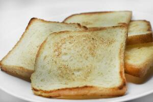 gebakken geroosterd brood Aan een wit bord. gebakken brood voor boterhammen. veganistisch voedsel. foto