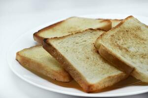 gebakken geroosterd brood Aan een wit bord. gebakken brood voor boterhammen. veganistisch voedsel. foto