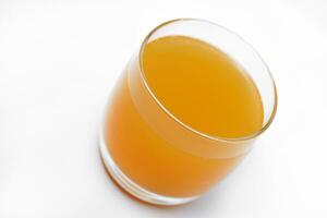 glas bril met oranje sap Aan een wit achtergrond. heerlijk oranje koeling drankje. foto